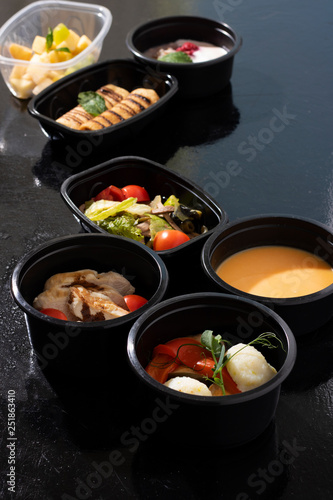 ready meal to eat in food containers, asian dishes on black table