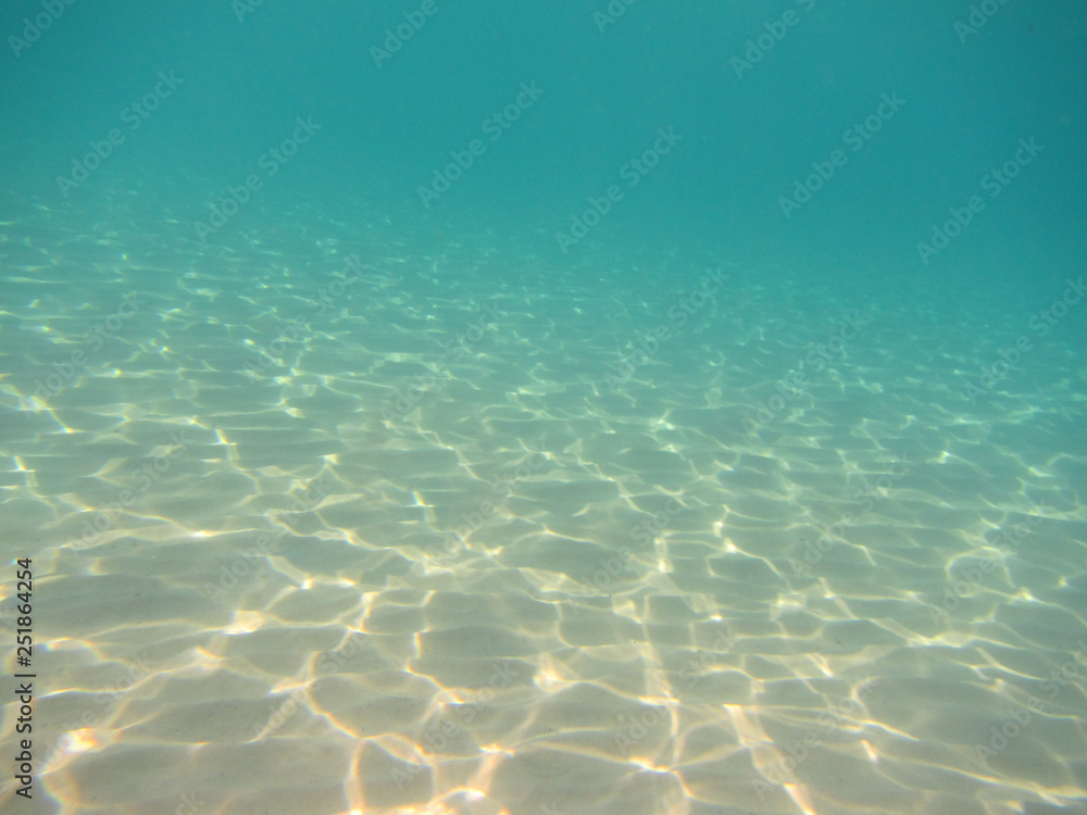Obraz premium underwater background with sandy sea bottom and reflections