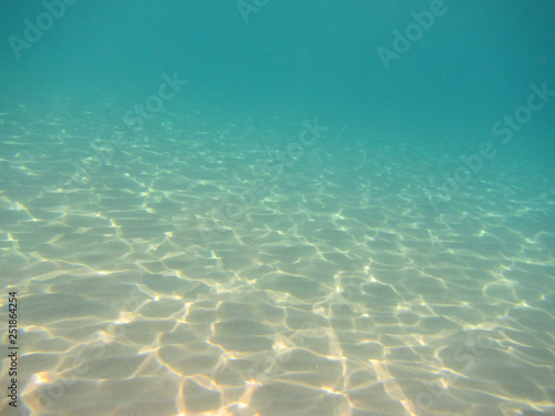 underwater background with sandy sea bottom and reflections