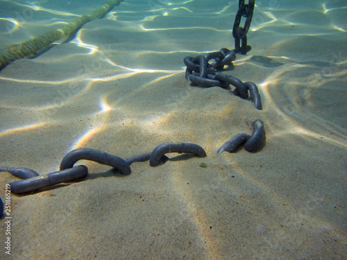 Seabed with sand and anchor chain, close up