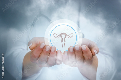 A gynecologist is holding a sphere with uterus image inside. photo