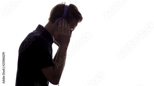 face profile silhouette of music lover teenager listening to favorite song in headphones , handsome young man on white isolated background, concept youth lifestyle, hobby