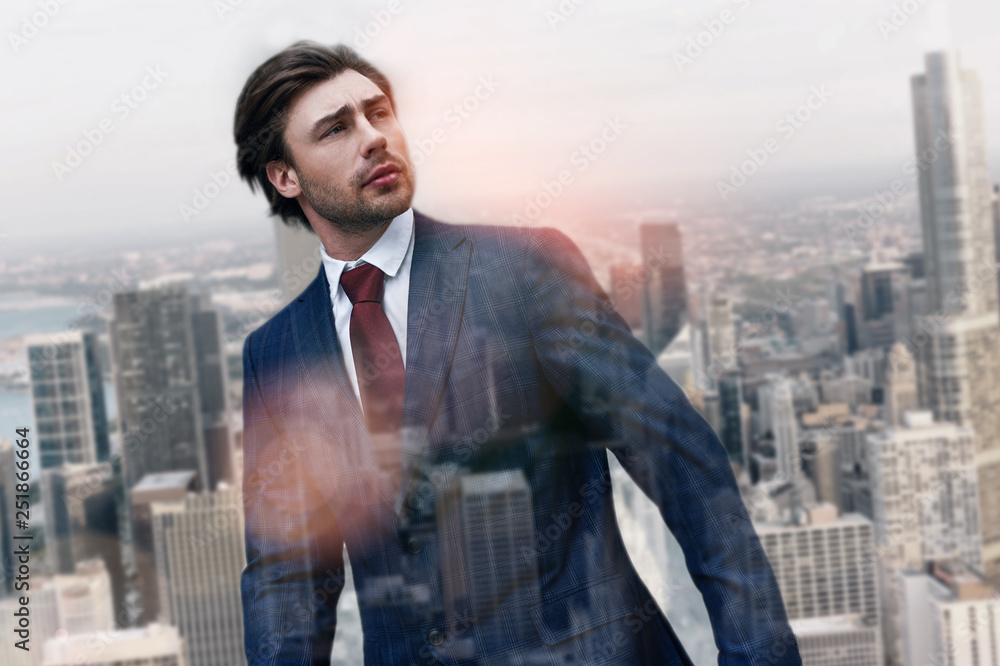 Thinking about future. Handsome businessman in stylish suit looking away while standing outdoors with cityscape on the background Thinking about future. Handsome businessman in stylish suit looking away while standing outdoors with cityscape on the background