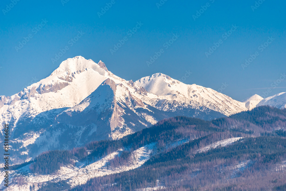 A beautiful view of the Polish Tatra Mountains. Sunny, beautiful day in the winter, snow-capped mountains and blue sky. A beautiful view of the Polish Tatra Mountains. Sunny, beautiful day in the winter, snow-capped mountains and blue sky.