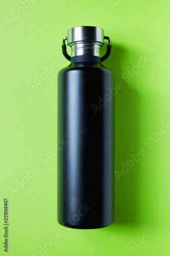 Black stainless steel water bottle on green