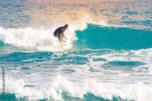 Surfer rides a wave on a surfboard. Surfing. Toned.