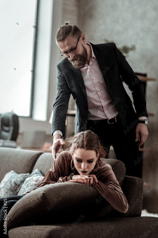 Fototapeta premium Businessman coming home and seeing daughter feeling depressed