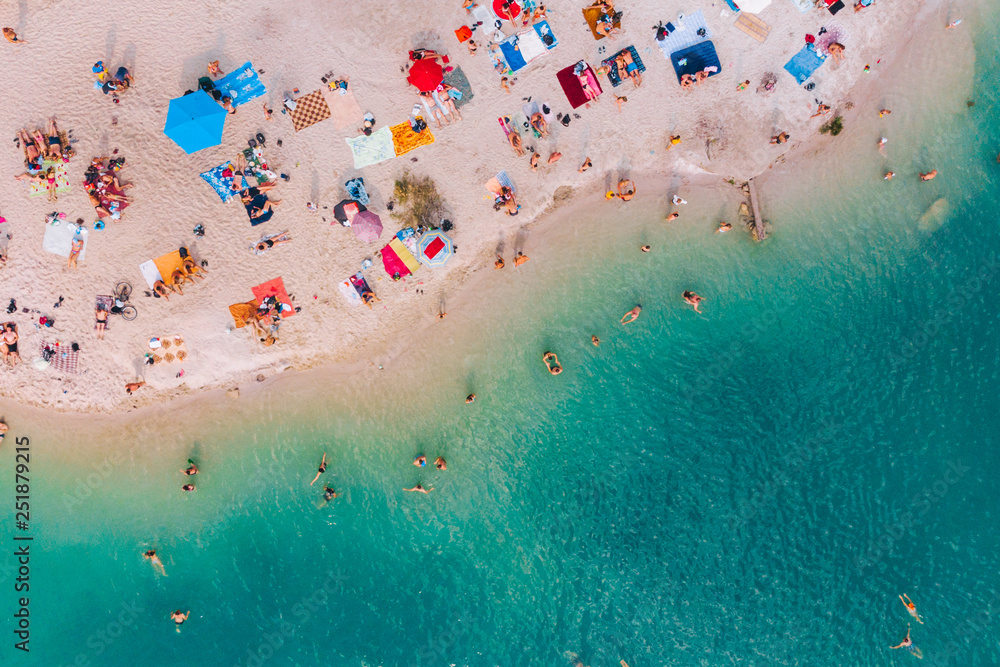 aerial view of sunny sandy beach with blue azure water