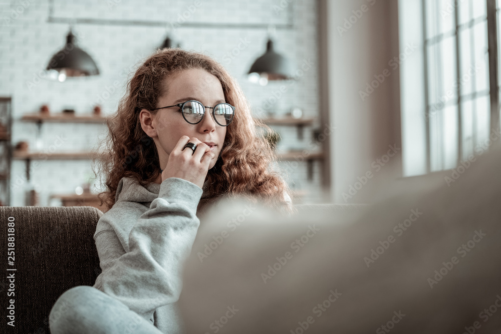 Girl wearing glasses feeling thoughtful talking to therapist Girl wearing glasses feeling thoughtful talking to therapist