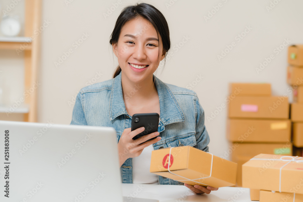 Beautiful smart Asian young entrepreneur business woman owner of SME checking product on stock scan qr code working at home. Small business owner at home office concept. Beautiful smart Asian young entrepreneur business woman owner of SME checking product on stock scan qr code working at home. Small business owner at home office concept.