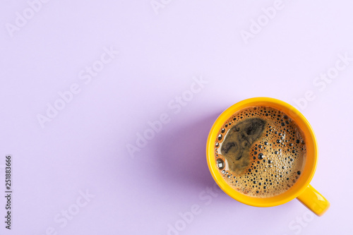 Cup of coffee on color background, space for text