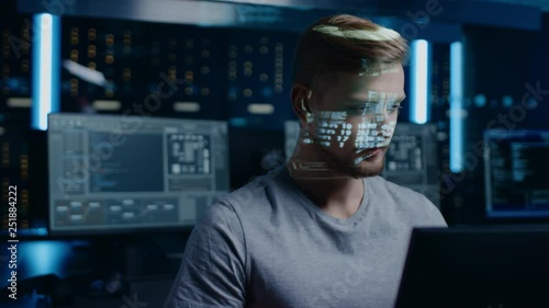 Portrait of Young Software Developer Working on Computer in Digital Identity Cyber Security Data Center, Projected Program Coding Language Reflects on Face. Futuristic Hacking and Programming Concept photo