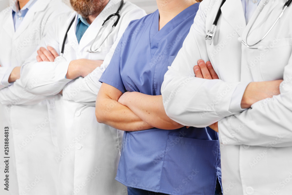 Doctors and nurses in healthcare team with arms crossed in a row in hospital Doctors and nurses in healthcare team with arms crossed in a row in hospital