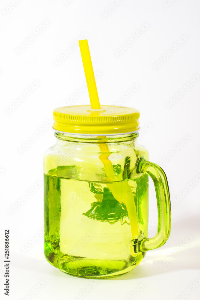 Green transparent glass with drinking straw on white background Green transparent glass with drinking straw on white background