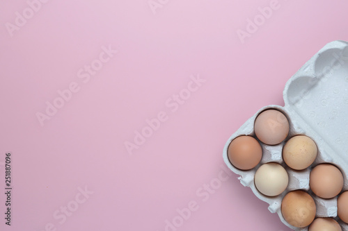 Chicken eggs in a paper tray on wooden background. Space for text. Flat lay photo