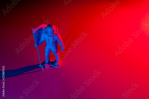 Fototapeta Naklejka Na Ścianę i Meble -  Lone Generic White Astronaut Figurine with American Flag in dramatic lighting
