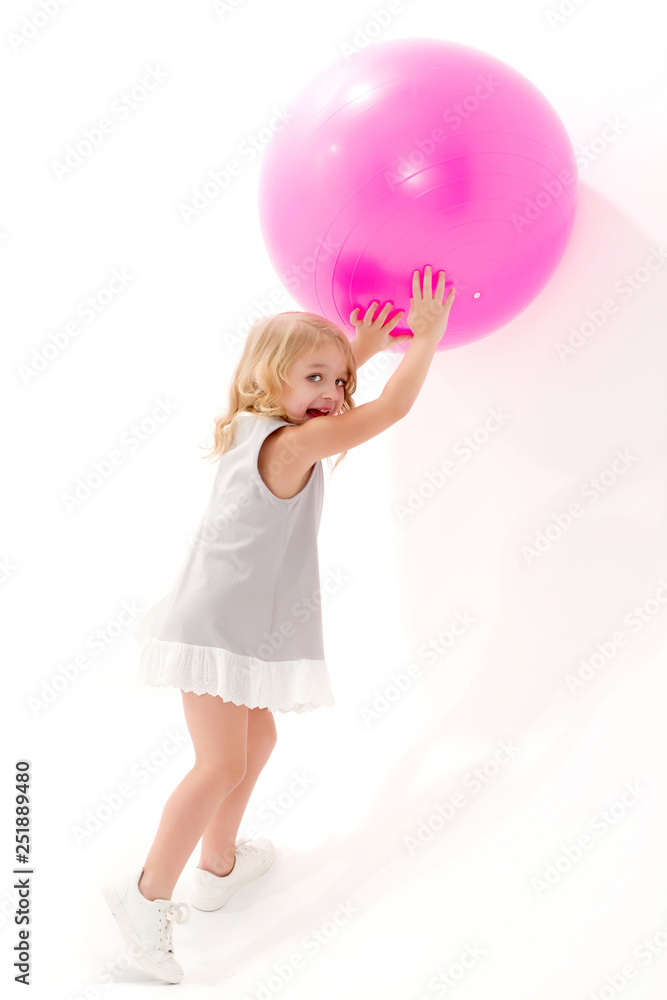 Little girl is playing with a ball