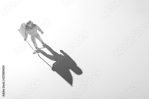 Fototapeta Naklejka Na Ścianę i Meble -  Lone Generic White Astronaut Figurine with American Flag in dramatic lighting