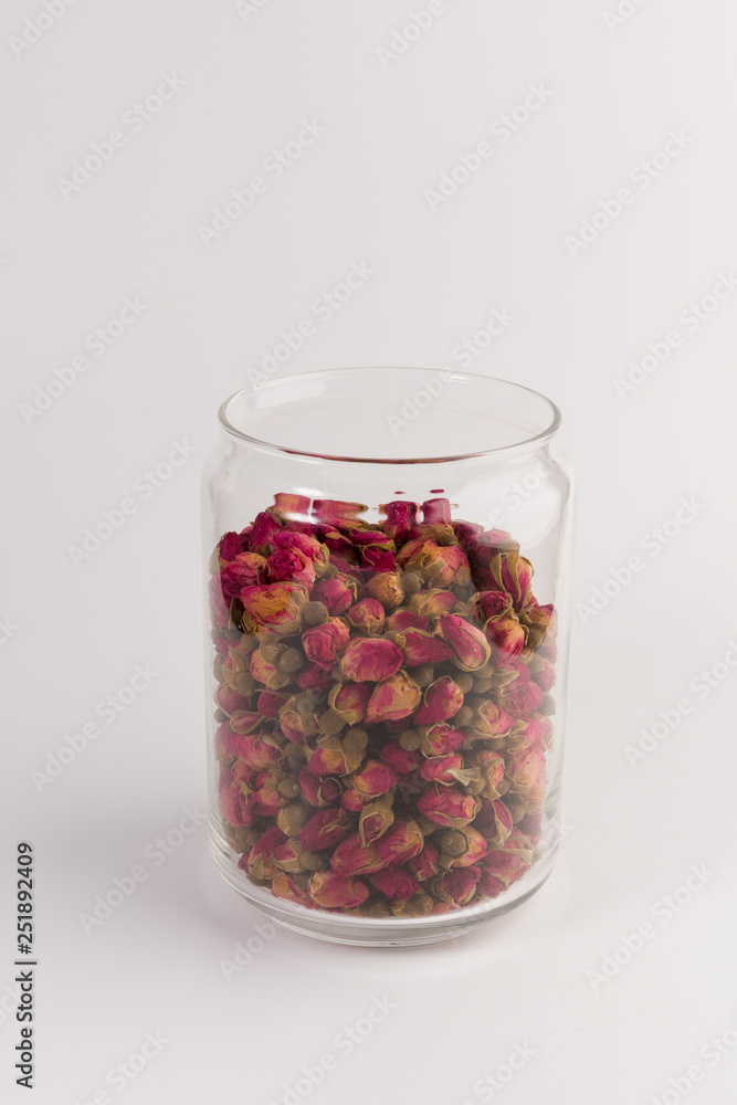 tea rose buds in the transparent jar isolated on white background tea rose buds in the transparent jar isolated on white background