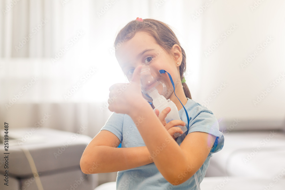 Little girl in a mask, treatments respiratory tract with a nebulizer at home