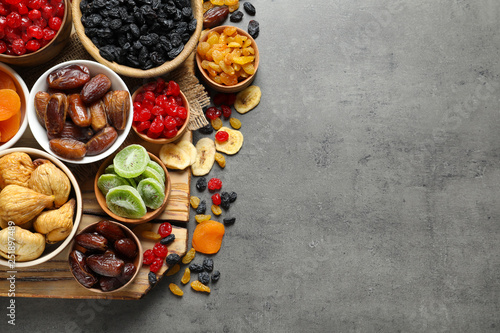 Fototapeta Naklejka Na Ścianę i Meble -  Bowls of different dried fruits on grey background, top view with space for text. Healthy food