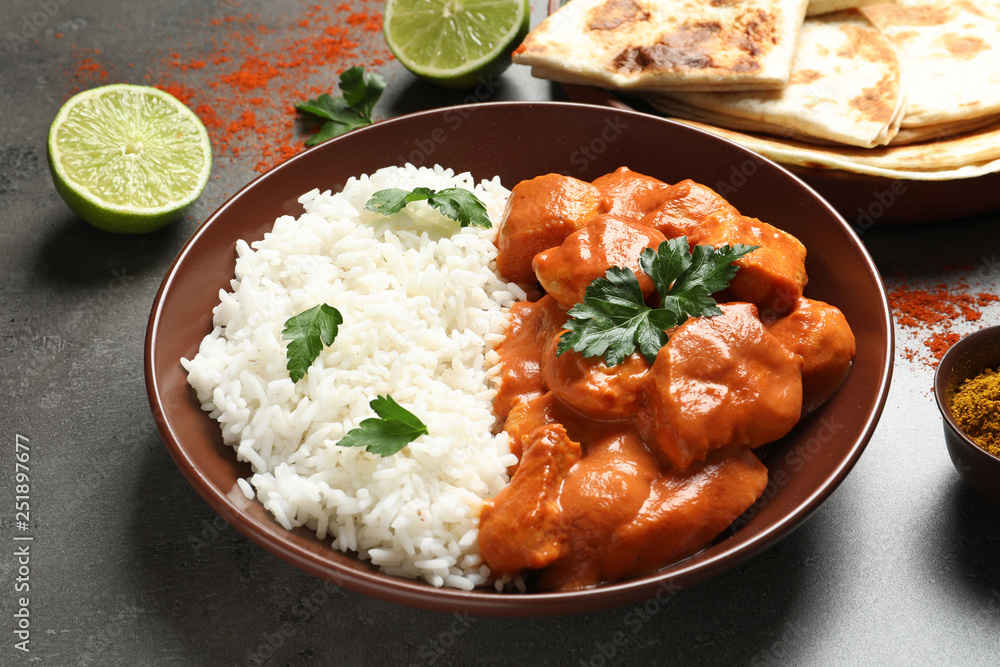 Delicious butter chicken with rice served on grey table Delicious butter chicken with rice served on grey table