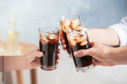 Friends with glasses of cold cola indoors, closeup