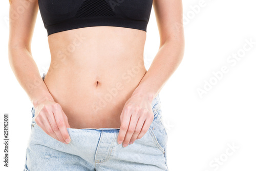 slim woman shows her weight loss by wearing an old jeans © OceanProd