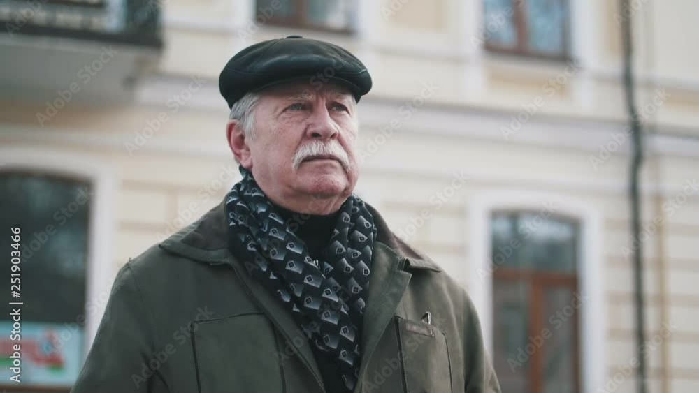 Confident senior man with mustache standing in a street in slow motion Confident senior man with mustache standing in a street in slow motion