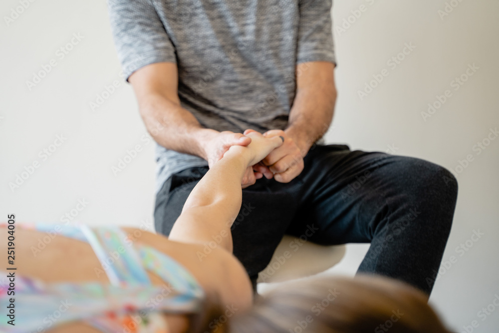 Fototapeta premium Manos de fisioterapeuta tratando la muñeca de deportista