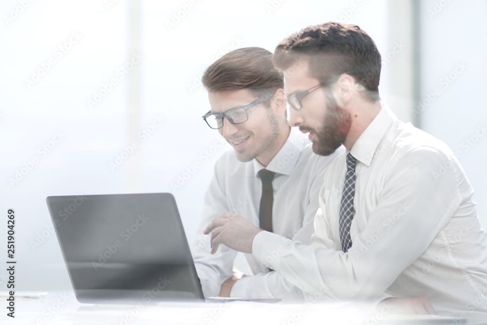 two business colleagues looking at the laptop screen two business colleagues looking at the laptop screen