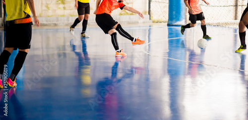Indoor soccer sports hall. Football futsal player, ball, futsal floor. Sports background. Youth futsal league. Indoor football players with classic soccer ball.
