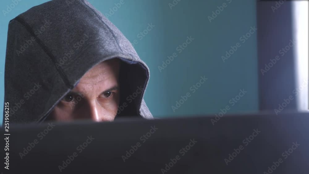 man hacker in the hood concept. unknown hacker lifestyle criminal breaks into computer protection on the Internet passwords. male hacker penetrates into hack network protection web phishing technology man hacker in the hood concept. unknown hacker lifestyle criminal breaks into computer protection on the Internet passwords. male hacker penetrates into hack network protection web phishing technology