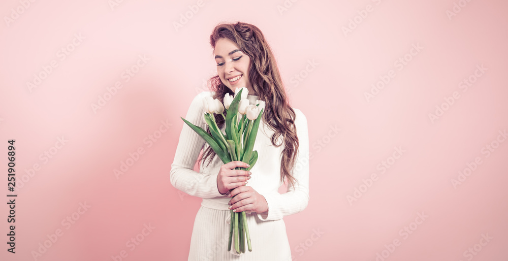 Young girl with tulips on a colored background Young girl with tulips on a colored background