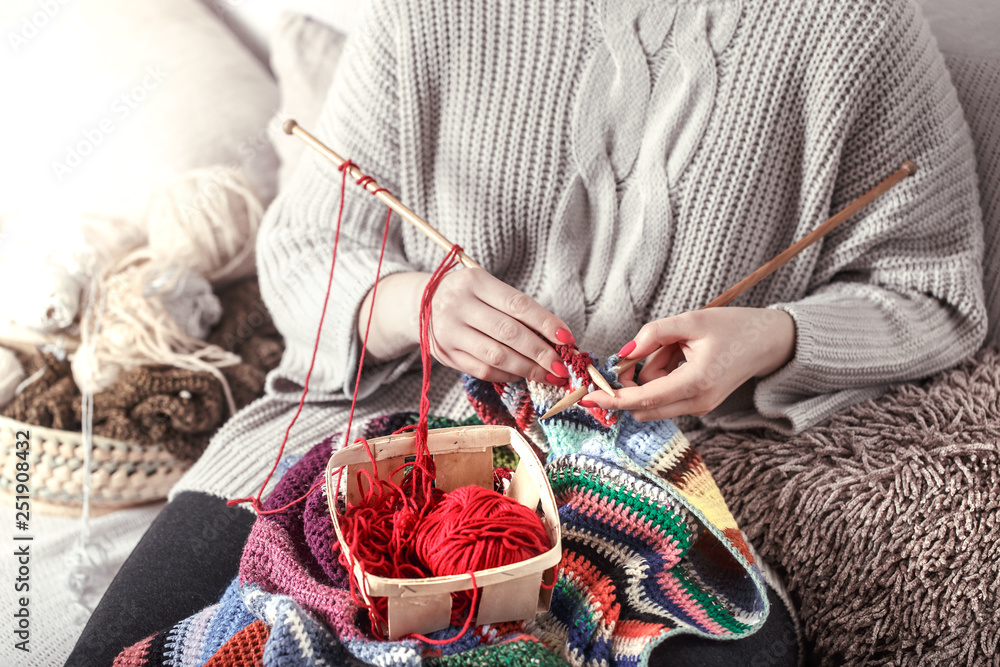 woman knits knitting needles on the couch