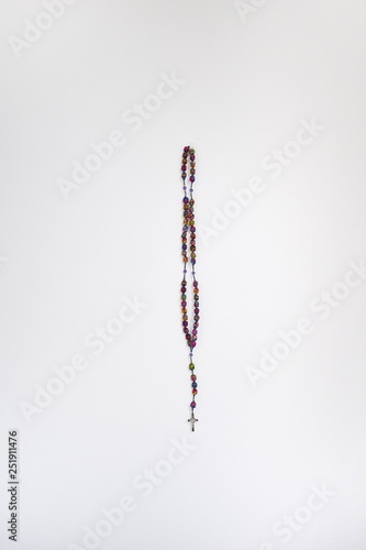 Colorful rosary against white wall
