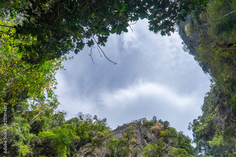 View of cloudy sky from Morakot Cave island (Emerald Cave) surround with trees and mountain.