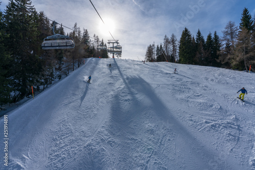 Aussicht von Waidring Steinplatte auf Winterlandschaft mit Schipiste und Schifahrer photo