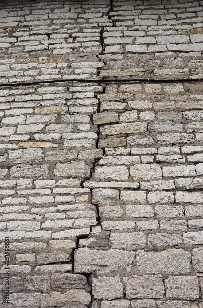 Stone wall texture. The crack in the fortress wall. Uneven rough stonework. Perfect for background and design.