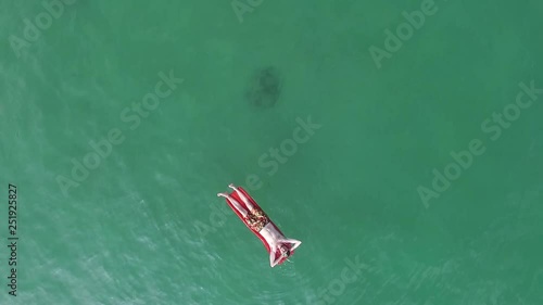 Aerial shot of a man sunbathing on the sea (ID: 251925827)