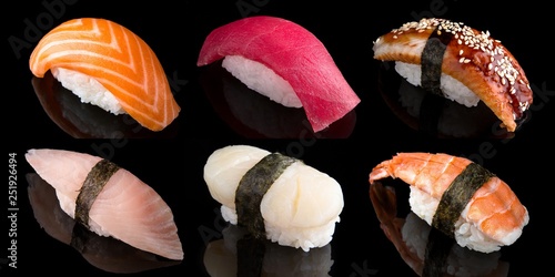 Sushi set of nigiri from salmon, tuna, shrimp, smoked eel, sea bass on black background. Traditional Japanese cuisine photo