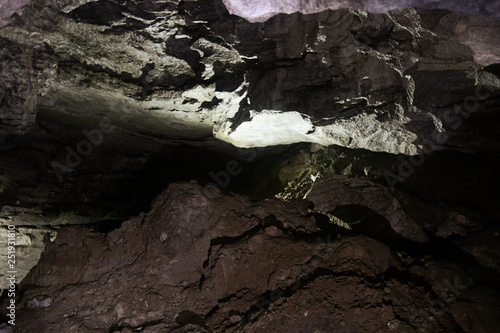 Half-filled with rock and clay natural cave. photo