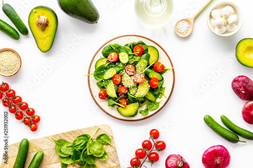 Preparing fresh salad. Vegetables, greens, spices on white background top view