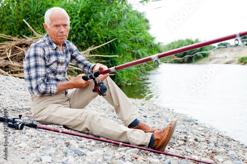 Aged man fishing at lakeside