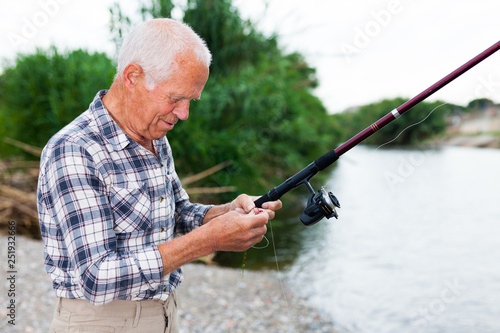 Mature man angling at riverside