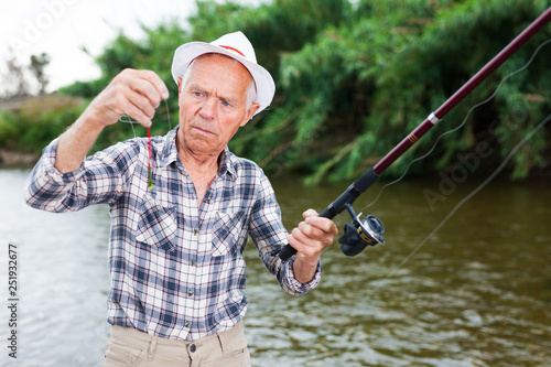 Fisherman changing bait on hook