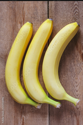three fresh bananas on wooden background