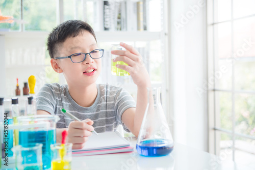 Young asian schoolboy doing chemistry experiment in laboratory classroom. Education concept.