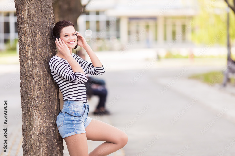 Young student leaning on a tree outdoors