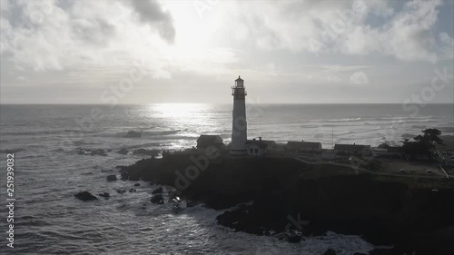 Close up  of the lighthouse on the coast in the pacific ocean, very cinematic, aerial shot